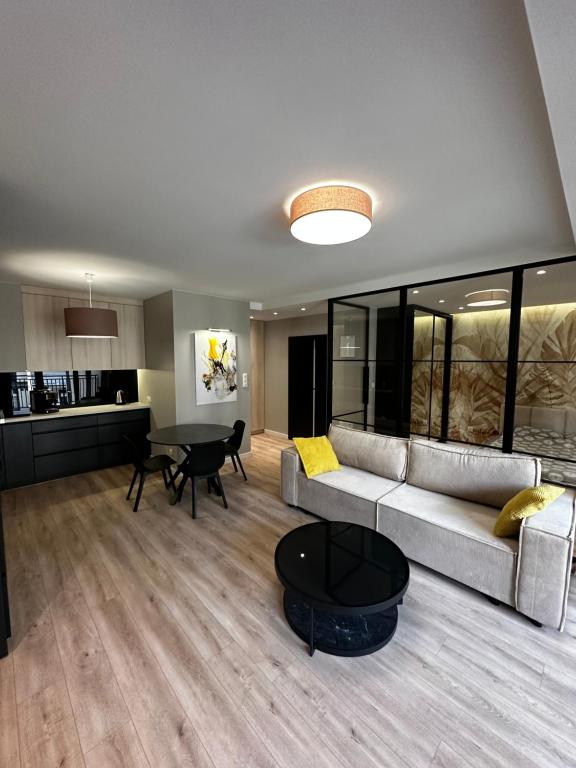 a living room with a couch and a table at Osiedle Legionów Apartament in Kielce