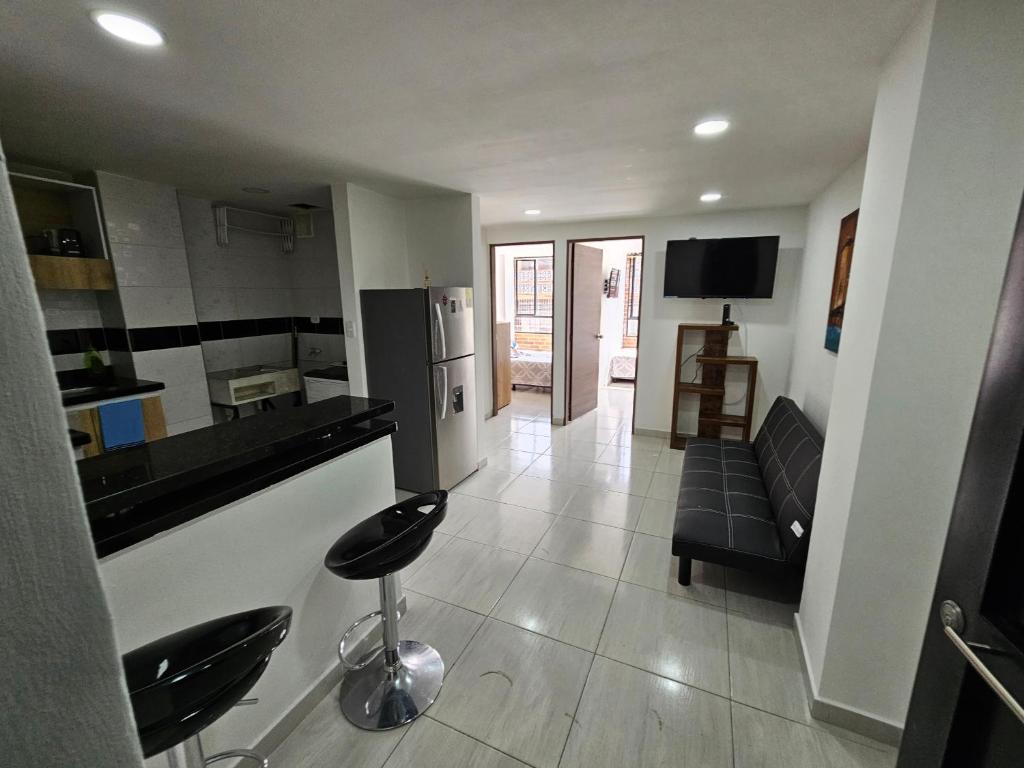 cocina y sala de estar con sofá en Increíble Apartamento Familiar, en Bogotá