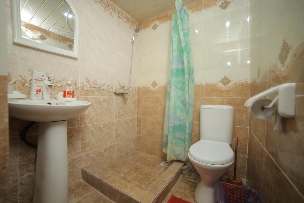 a bathroom with a toilet and a sink and a shower at Rustambey House in Khiva