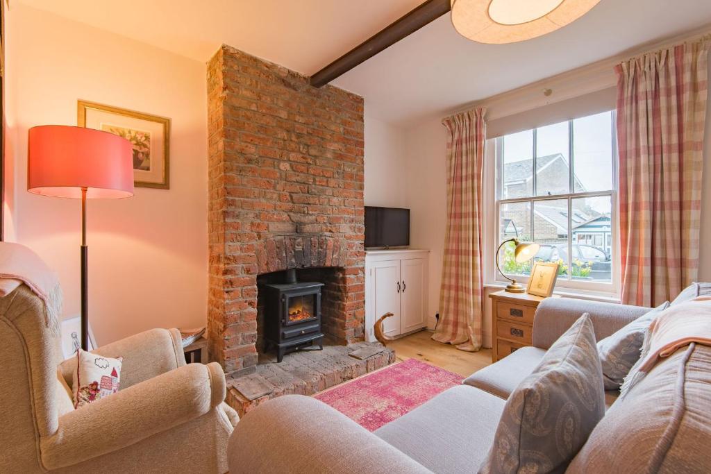 a living room with a fireplace and a couch at Bunny Cottage by Bloom Stays in Hythe