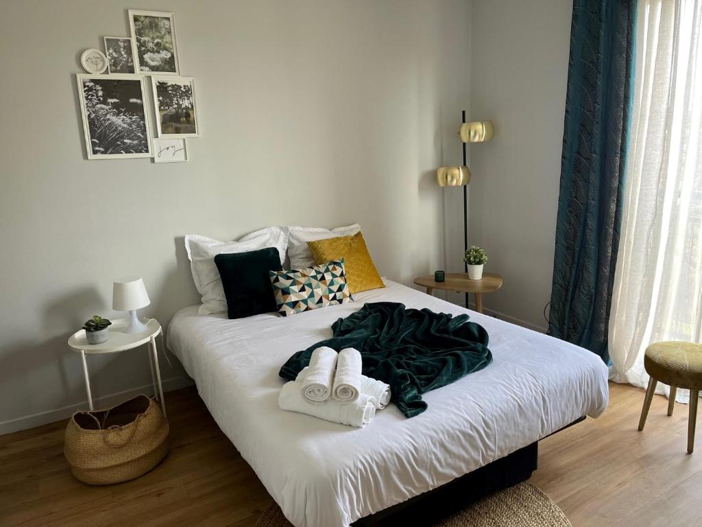 - une chambre avec un lit et des serviettes dans l'établissement Appartement - cœur de Ramonville, à Ramonville-Saint-Agne