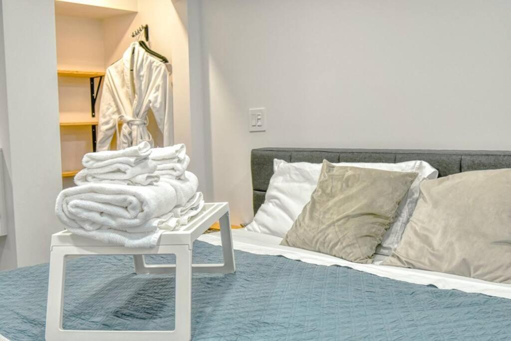 Una cama con una mesa blanca con una toalla. en The Ox + Bow, en Portage La Prairie