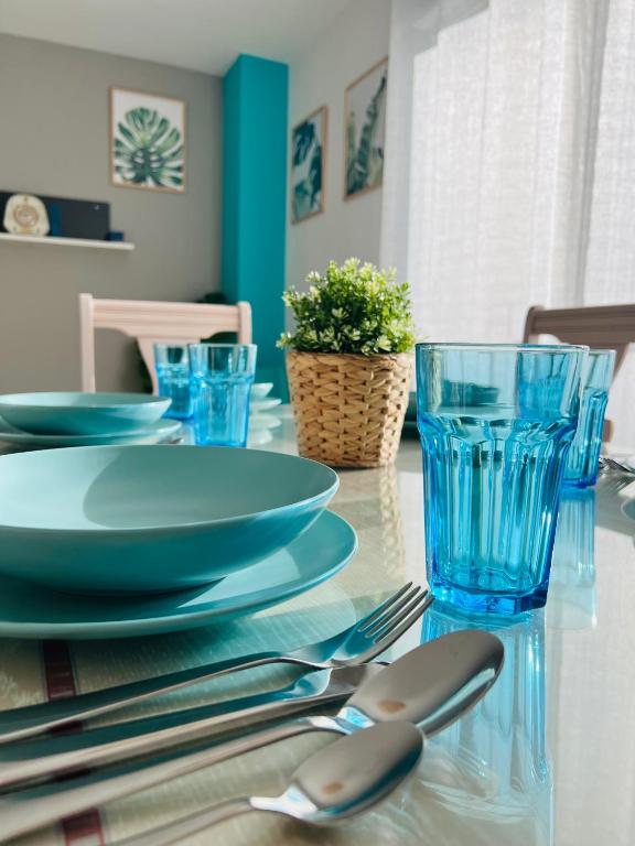 佩尼斯科拉APARTAMENTO SITUADO EN EL CENTRO CON 3 HABITACIONES, DISPONE DE AIRE ACONDICIONADO Y WIFI A 150m DE LA PLAYA Y EL CASTILLO的一张桌子上摆着蓝色的盘子和餐具