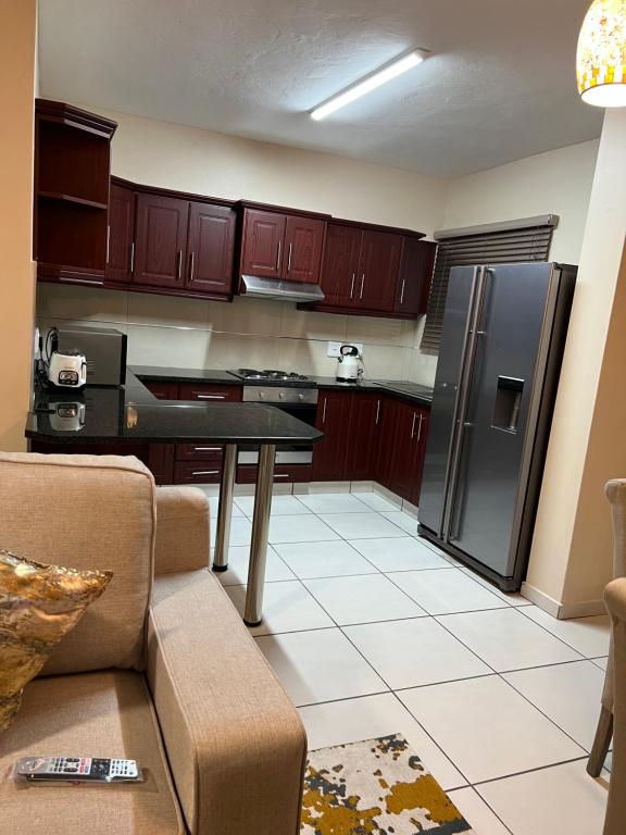 リチャーズ・ベイにあるIsibani luxury apartmentのキッチン(木製キャビネット、黒い冷蔵庫付)