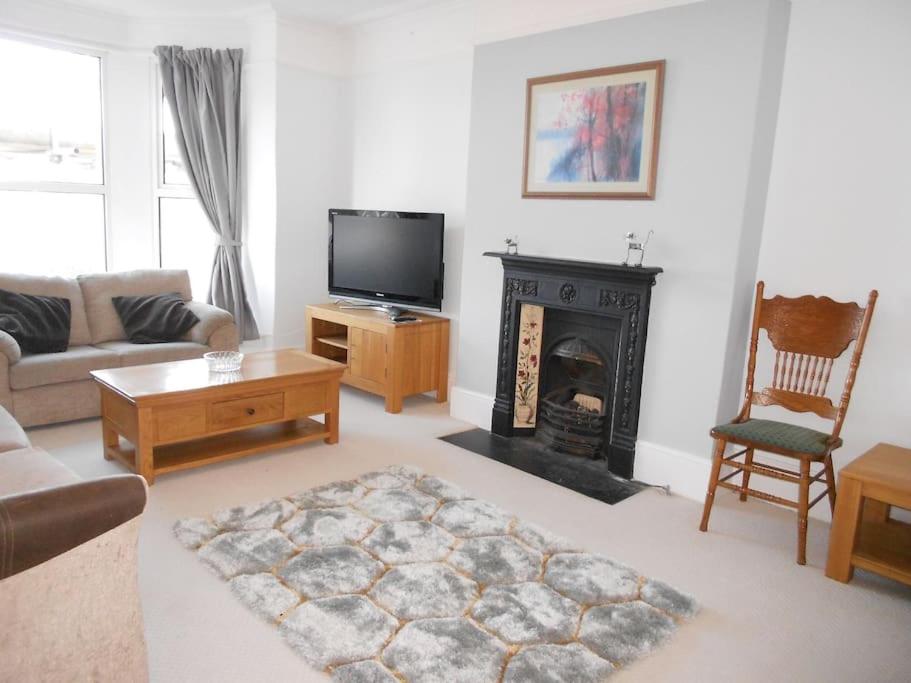 ein Wohnzimmer mit einem Sofa und einem Kamin in der Unterkunft Hillsborough View in Ilfracombe