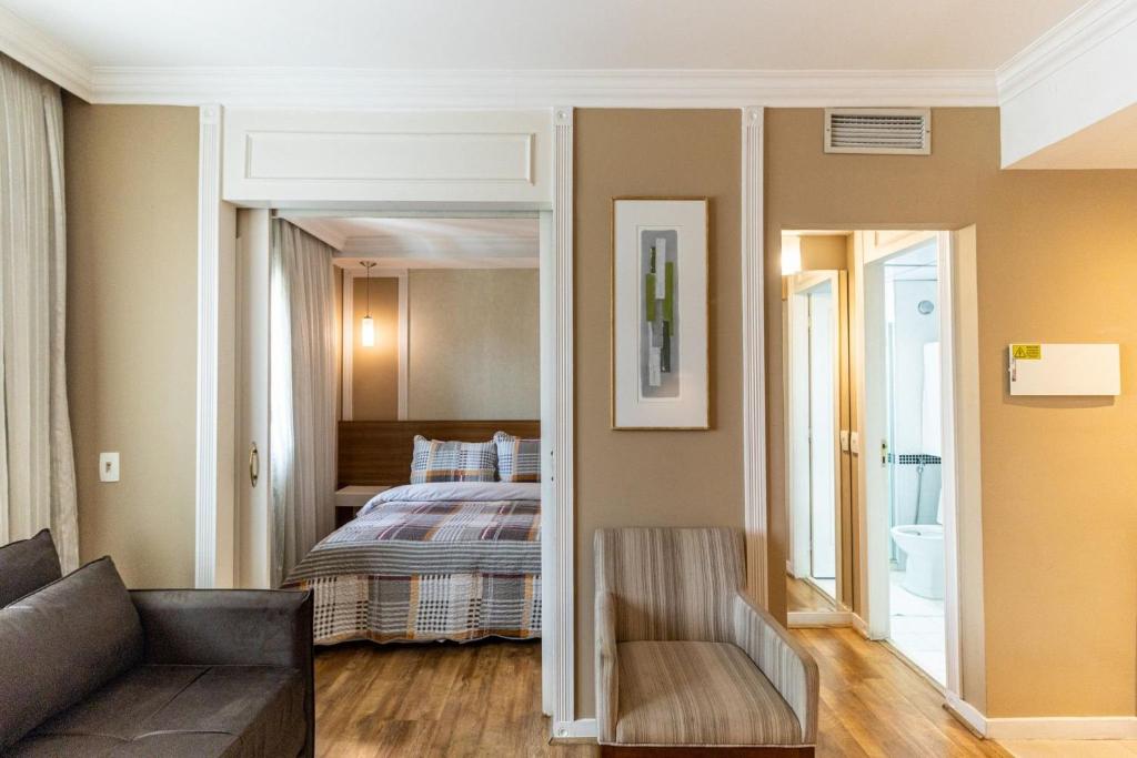 uma sala de estar com um sofá e uma cama em Kaza Noah The Universe Paulista Bela Vista em São Paulo