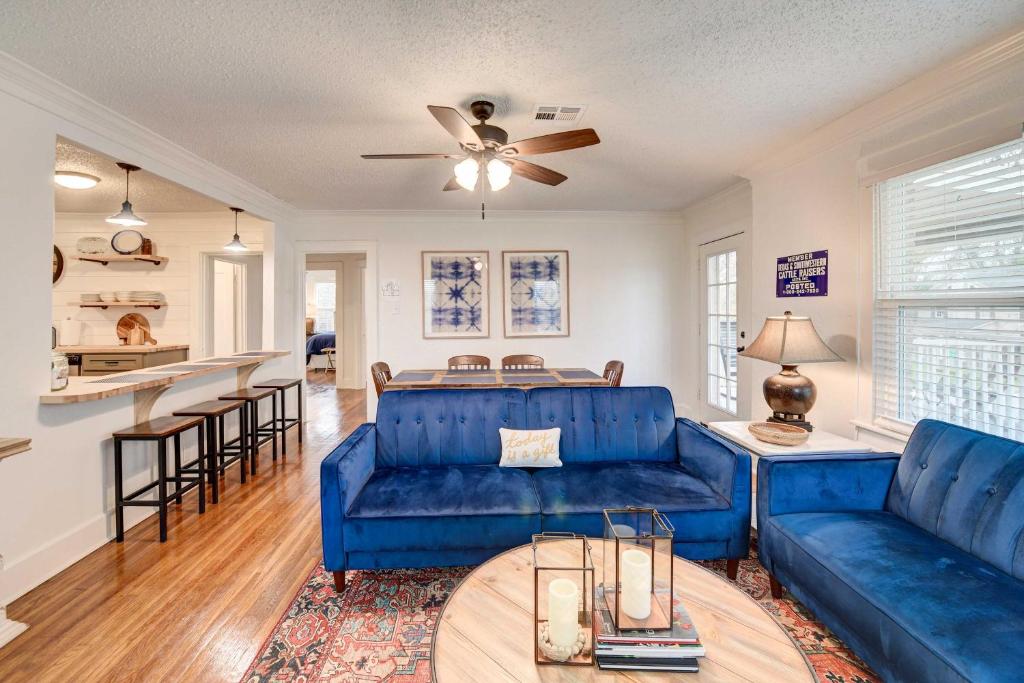 a living room with blue couches and a kitchen at Vacation Rental about 2 Mi to Magnolia Market! in Waco
