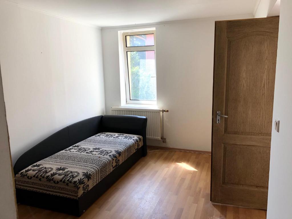 ein kleines Schlafzimmer mit einem Bett und einem Fenster in der Unterkunft Feel Natural and Relaxed in a 3 Bedroom Apartment in Gyongyosfalu in Gyöngyösfalu