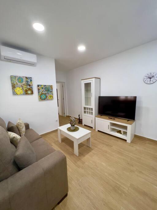sala de estar con sofá y TV de pantalla plana en RockSide Residences Suites La Línea N4, en La Línea de la Concepción