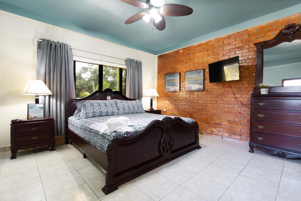 a bedroom with a bed and a brick wall at Sea Eye Hotel - Tropical Building in Utila