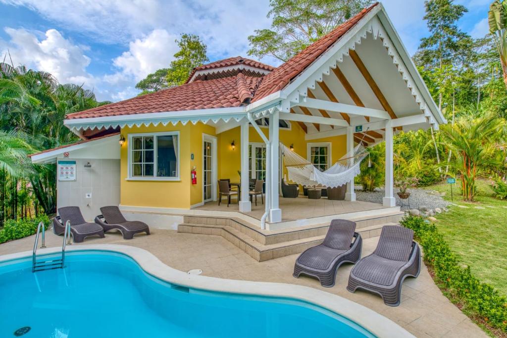 une maison avec une piscine en face de celle-ci dans l'établissement Lomas del Caribe, à Puerto Viejo