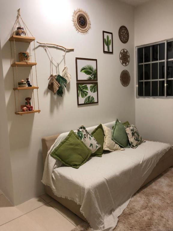 a bed with green pillows in a room at Casa privado com 3 quartos e piscina in Logradouro