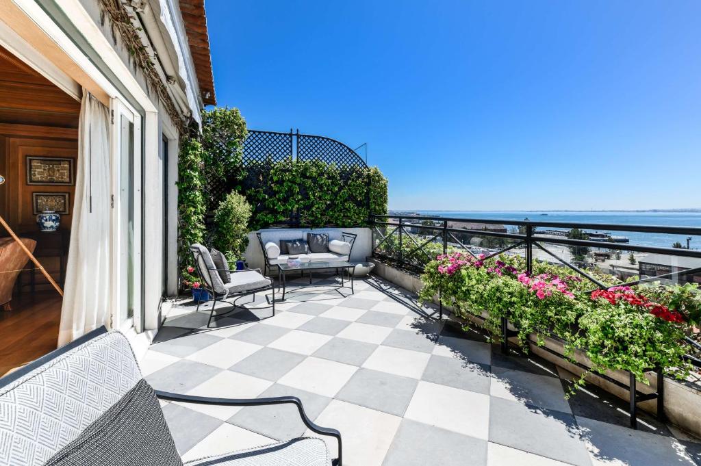 a patio with chairs and flowers on a balcony at As Janelas Verdes Inn - Lisbon Heritage Collection - Riverside in Lisbon