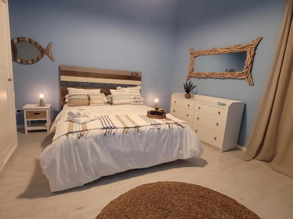 a bedroom with a bed and a dresser and a mirror at Magellano Suite. Fronte Mare + Free Park + Wi-Fi in Porto Empedocle