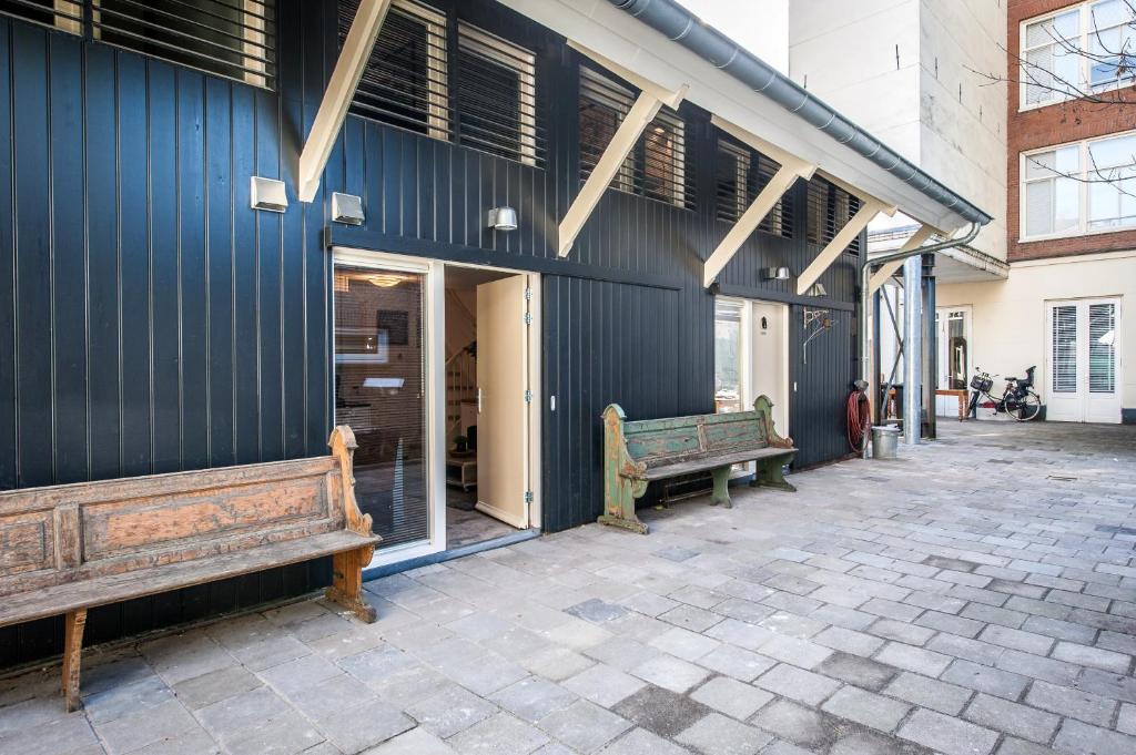 two benches are sitting outside of a building at Plantage Garden Apartments in Amsterdam