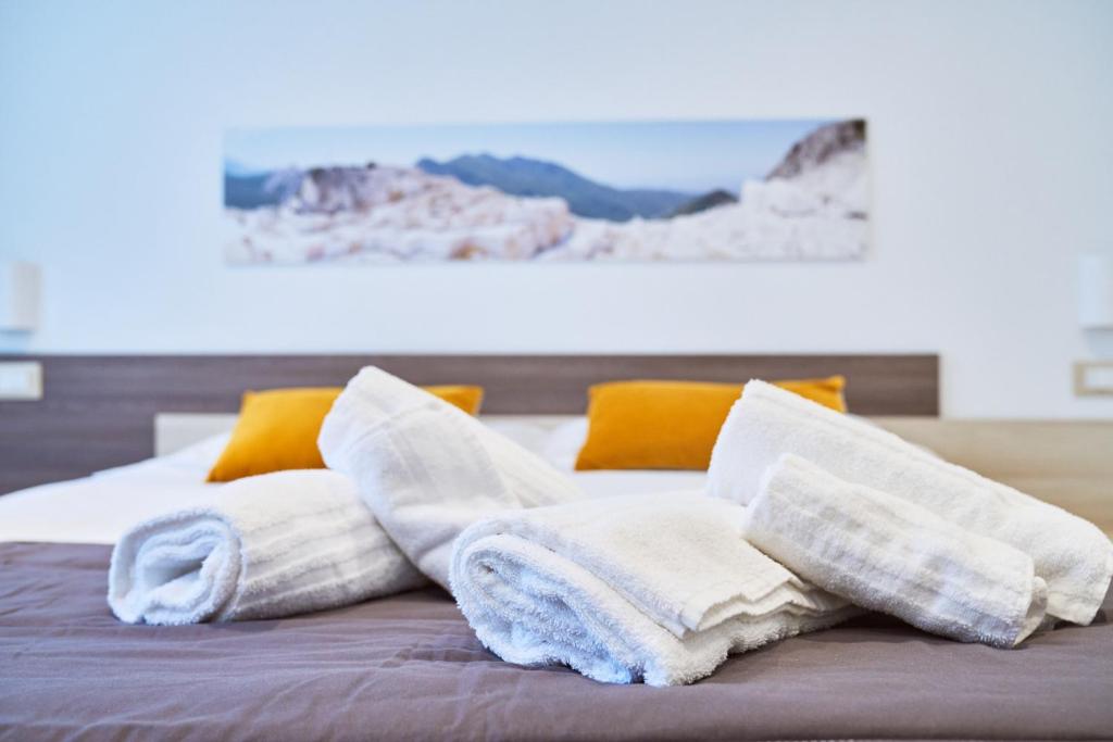 サルザーナにあるFirmafede Guest Houseのベッドの上に座るタオルの山