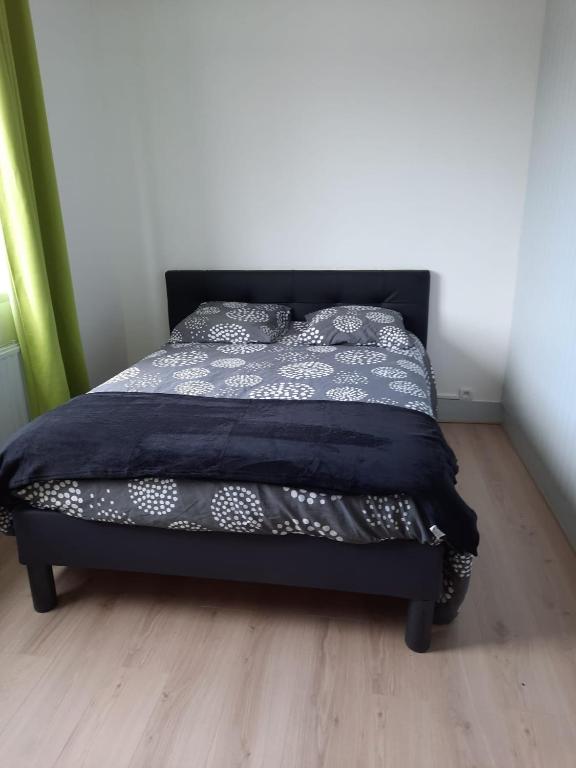 una camera da letto con un letto con un piumone blu di une détente à la plage a Dunkerque