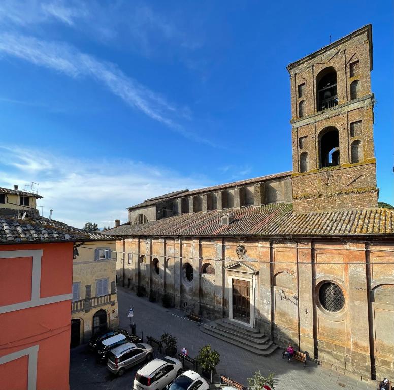 ein altes Gebäude mit Autos auf einem Parkplatz in der Unterkunft Nepi - Appartamento Centro Storico Duomo in Nepi