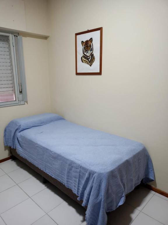 a bedroom with a bed with a blue blanket at Rincón Verde in San Miguel de Tucumán
