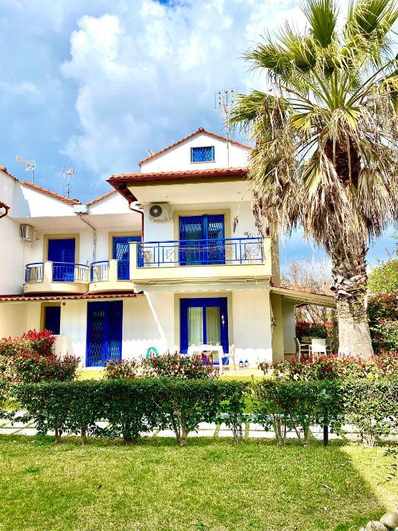 a large house with a palm tree in front of it at Fourka House in Kassandra