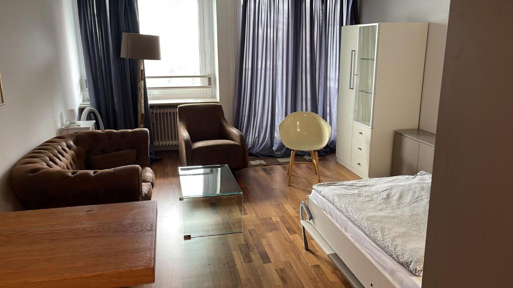 a bedroom with a bed and a couch and a chair at Apartment in München in Munich
