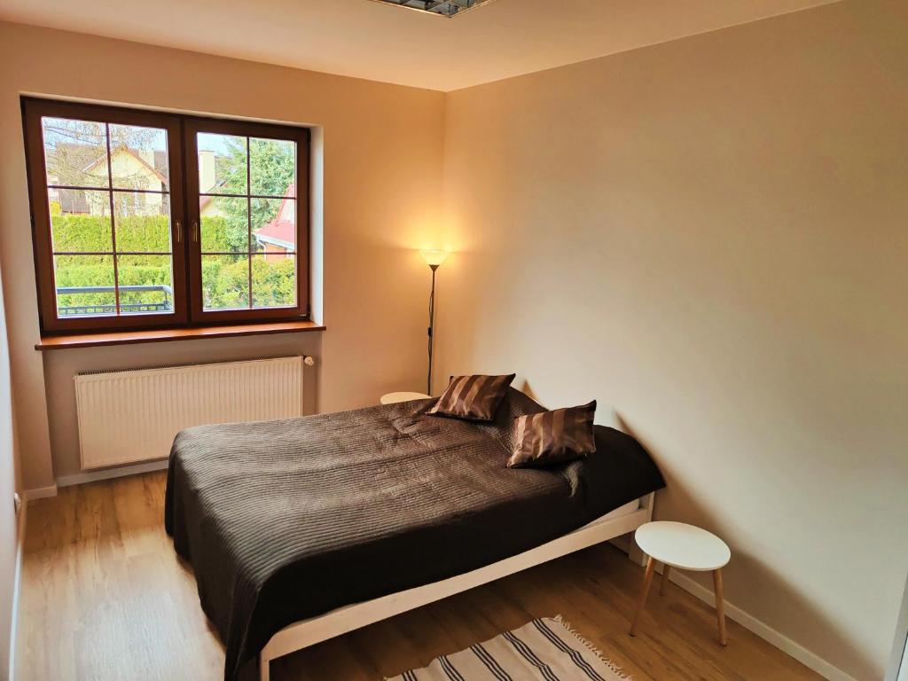 1 dormitorio con cama y ventana en Villa Krasnowolska Airport - Self Check-in en Varsovia