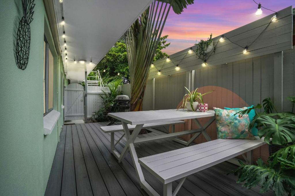 a patio with a table and bench on a deck at Tropicana Pineapple in Cairns North