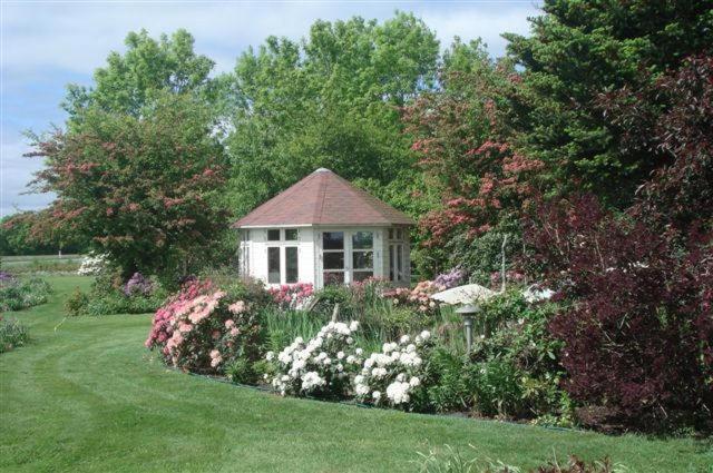 a small house in the middle of a garden at Agervig Bed & Breakfast in Næsbjerg