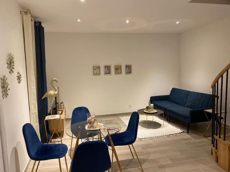 a living room with a blue couch and chairs at Le Duplex de l’Avenue in Chalon-sur-Saône