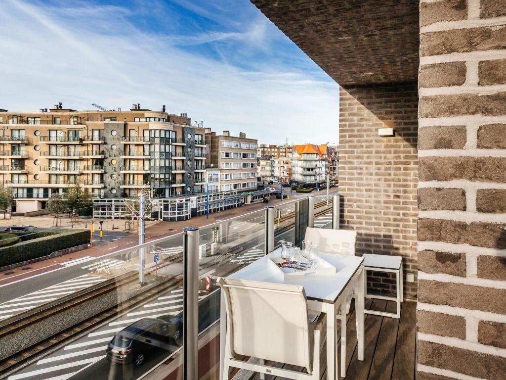 d'une table et de chaises sur un balcon avec vue sur la ville. dans l'établissement Modern apartment in Koksijde with balcony, à Coxyde