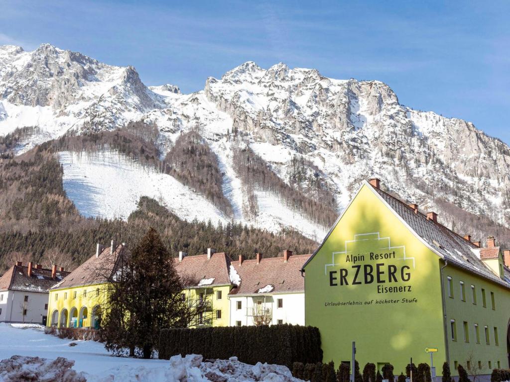 a building with a sign in front of a mountain at Apartment Seemauer am Erzberg in Eisenerz