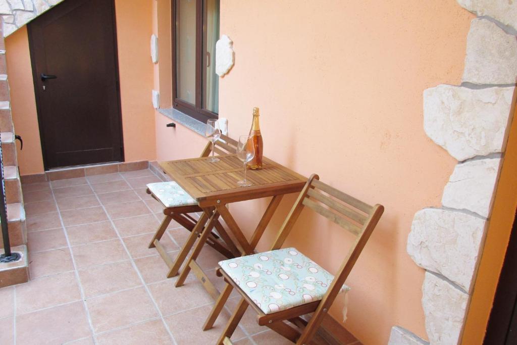 a table and two chairs and a bottle of wine at Apartments by the sea Cres - 8095 in Cres