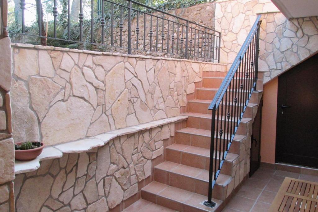 a stairway with a stone wall and a railing at Apartments by the sea Cres - 8095 in Cres