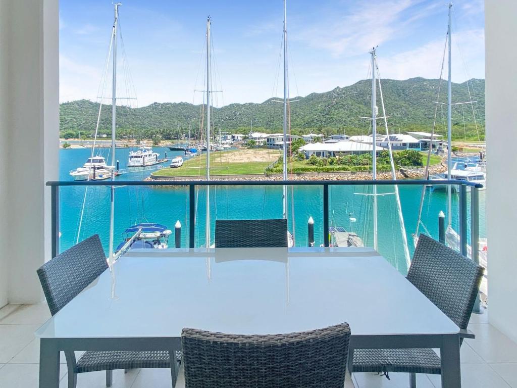 a table with chairs and a view of a marina at Blue on Blue Superior Studio Room 1351 in Nelly Bay