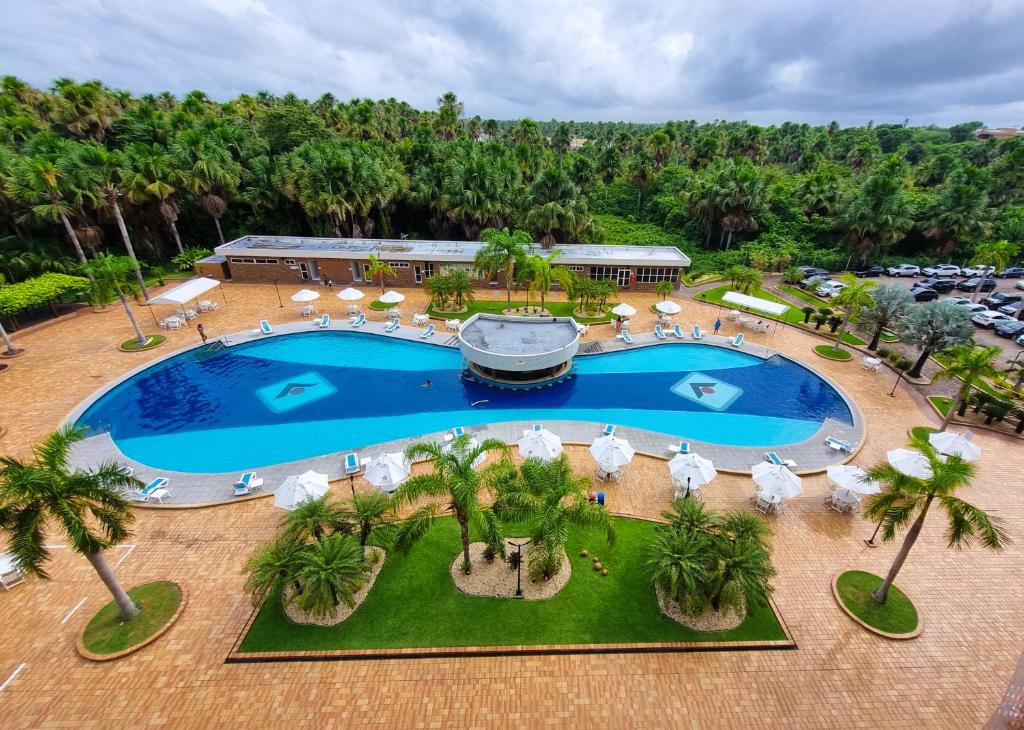 una vista aérea de una piscina con sombrillas y palmeras en GRAN LENÇÓIS FLAT RESIDENCE, en Barreirinhas