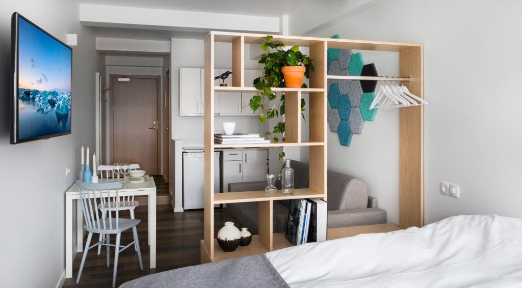 a room with a bed and a book shelf with a desk at Island Apartments in Reykjavík