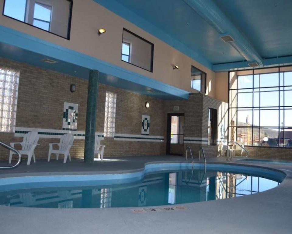 a swimming pool in a building with a table and chairs at Wingate by Wyndham Gunnison Near Western Colorado University in Gunnison