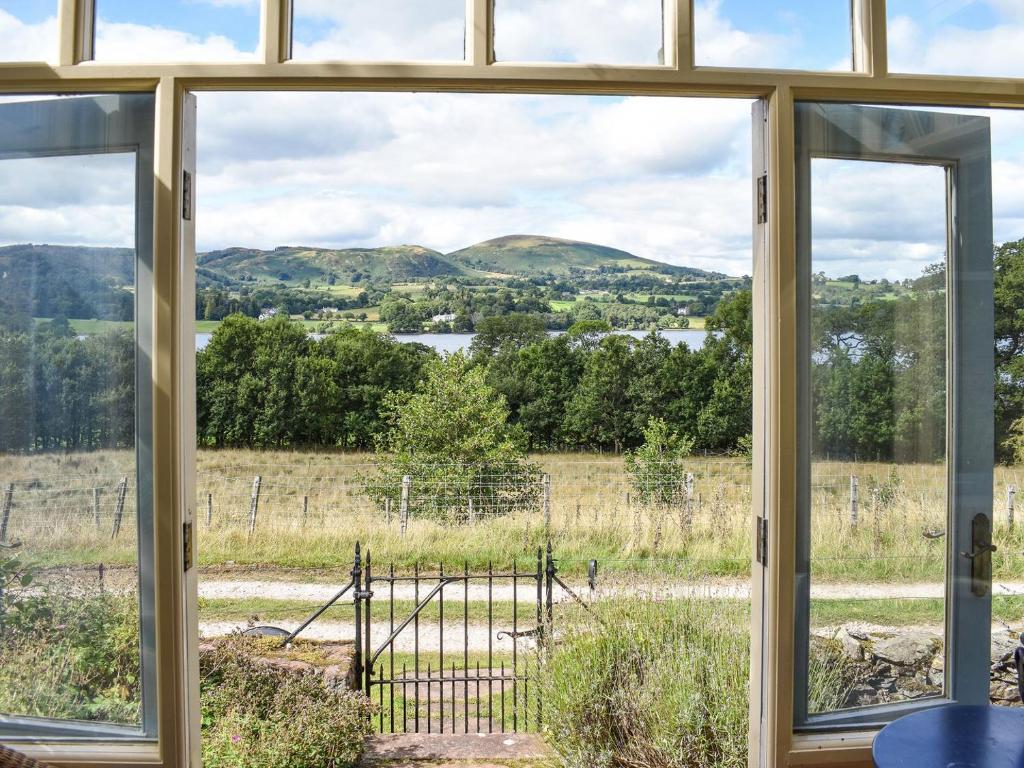 a window view of a field and mountains from a house at Sharrow Cottage in Watermillock