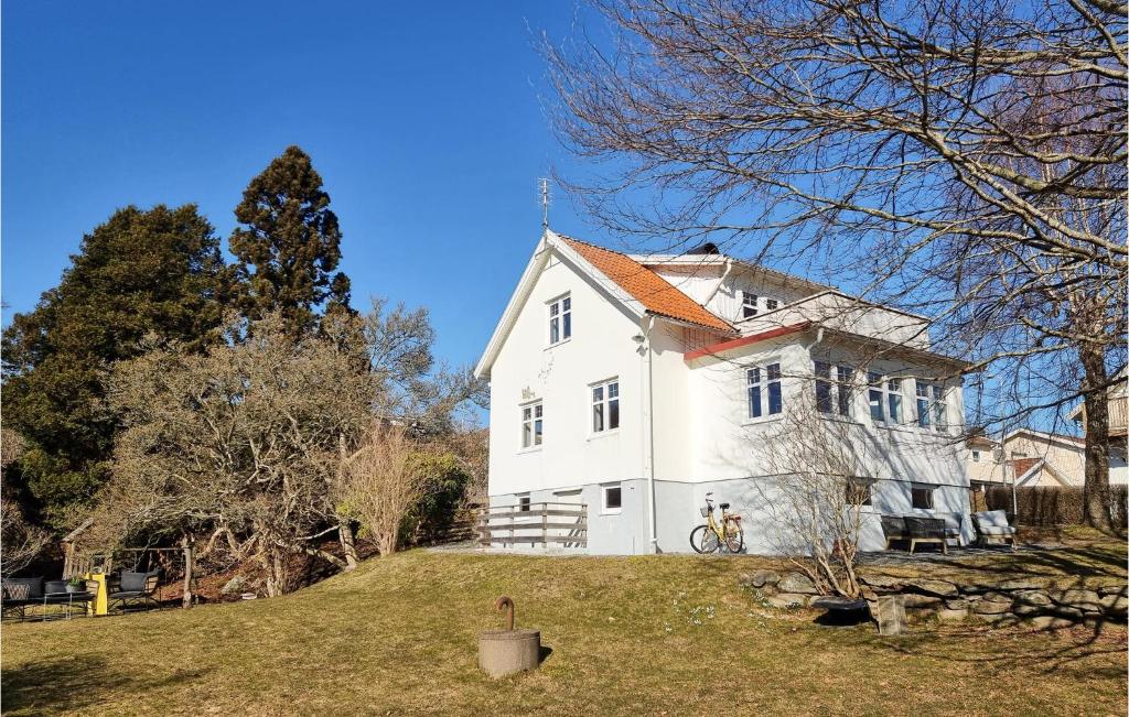 ein großes weißes Haus auf einem grasbewachsenen Hügel in der Unterkunft Cozy Home In Svanesund With Kitchen in Svanesund