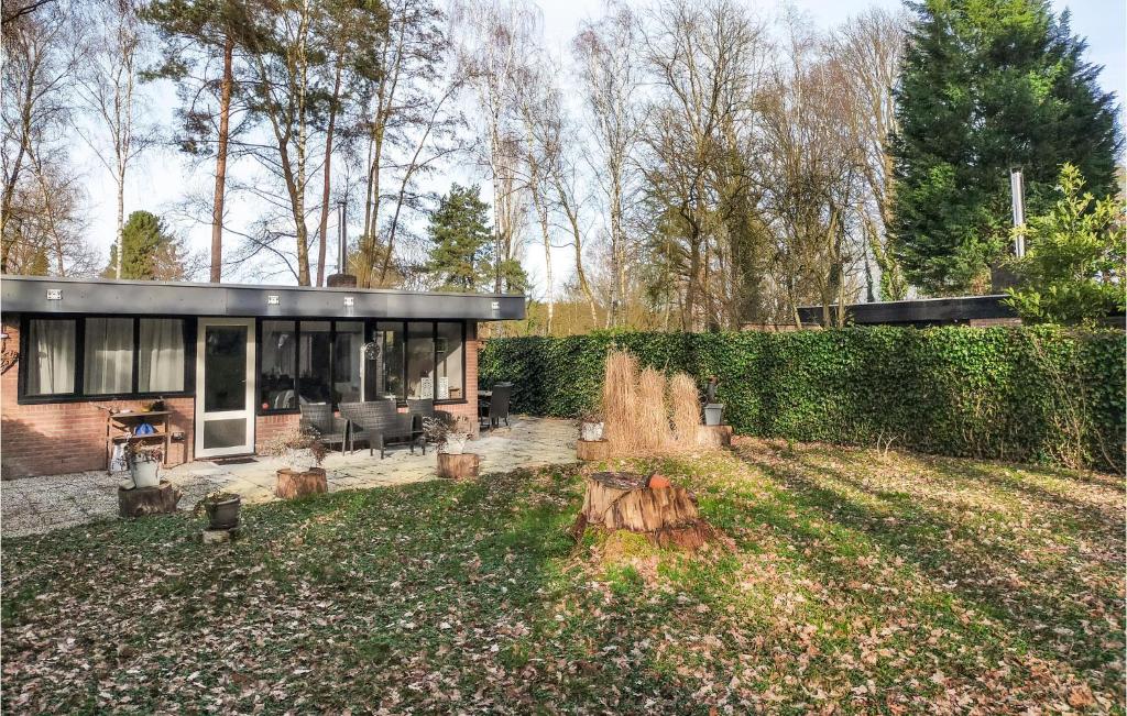 una casa con un tronco de árbol en el patio en 2 Bedroom Gorgeous Home In Rekem-lanaken en Bovenwezet