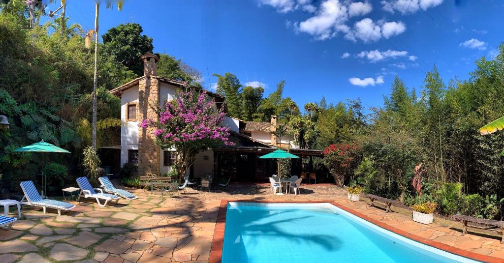 a swimming pool in front of a house at Pousada Valle Paradiso in Itaipava