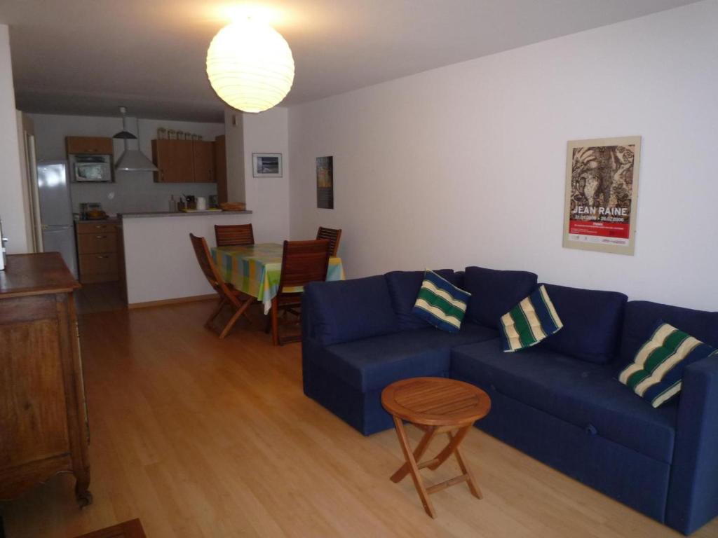 uma sala de estar com um sofá azul e uma mesa em Appartement Les Sables-d'Olonne, 2 pièces, 4 personnes - FR-1-92-699 em Les Sables-dʼOlonne
