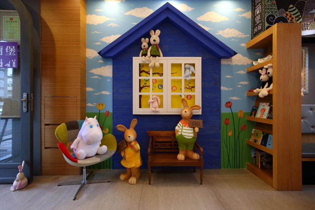 una habitación con una casa azul con animales de peluche en Holland Windmill B&B, en Hualien City