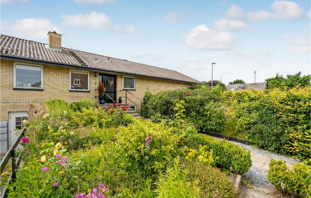 een huis met een tuin met bloemen bij 4 Bedroom Lovely Home In Frederikshavn in Frederikshavn