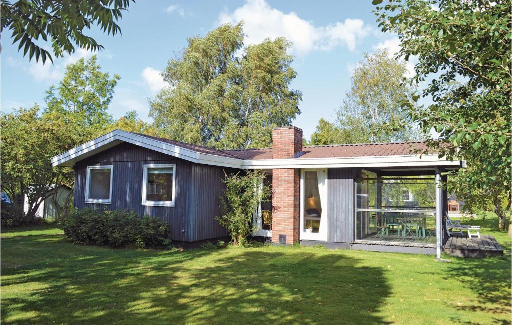 a small house in a field with a grass yard at Holiday Home Strandkrogen Ix in Dronningmølle