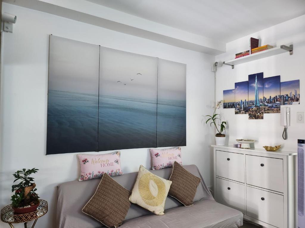 マニラにあるJana@ShoreC2のソファと壁に絵が飾られたリビングルーム