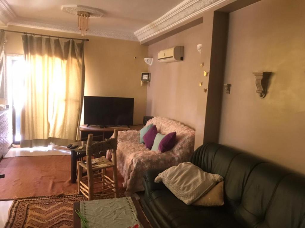 ein Wohnzimmer mit einem grünen Sofa und einem Tisch in der Unterkunft Walid in Marrakesch