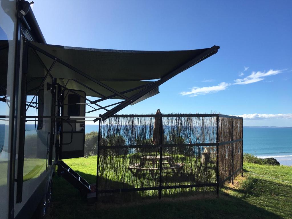 un porche cubierto con vistas al océano en 90 Mile Paradise - luxury experience, en Ahipara