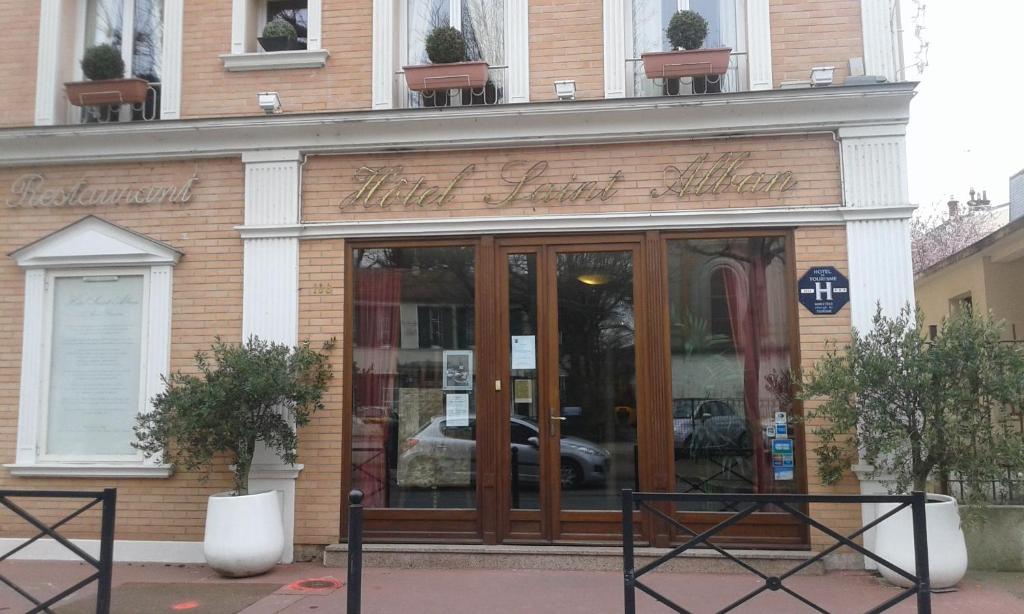 a store front of a building with glass doors at Hôtel Saint Alban in Saint-Maur-des-Fossés