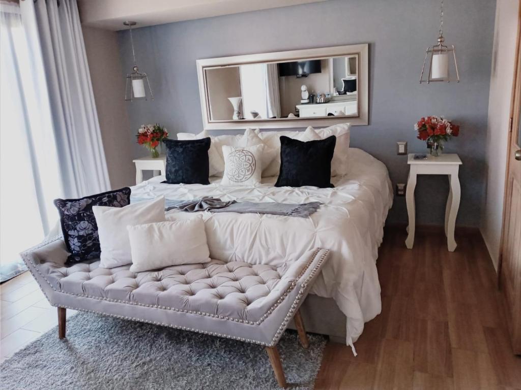 ein Schlafzimmer mit einem großen Bett, einer Couch und einem Spiegel in der Unterkunft Casa Neek in San Cristóbal de las Casas